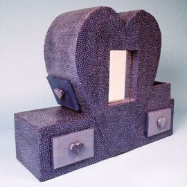 Coiffeuse en forme de cœur avec miroir et tiroirs décoratifs.