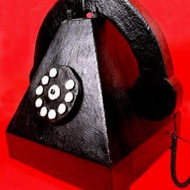 Téléphone en forme de pyramide, noir, avec un combiné et un cadran à boutons blancs.